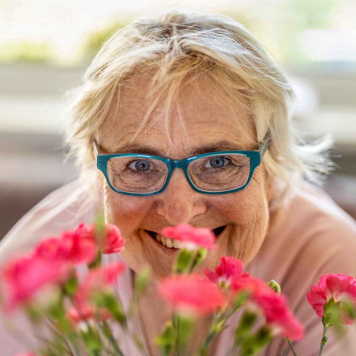 Someren Glen Senior Living Community in Centennial, CO - sg senior woman peering over flowers