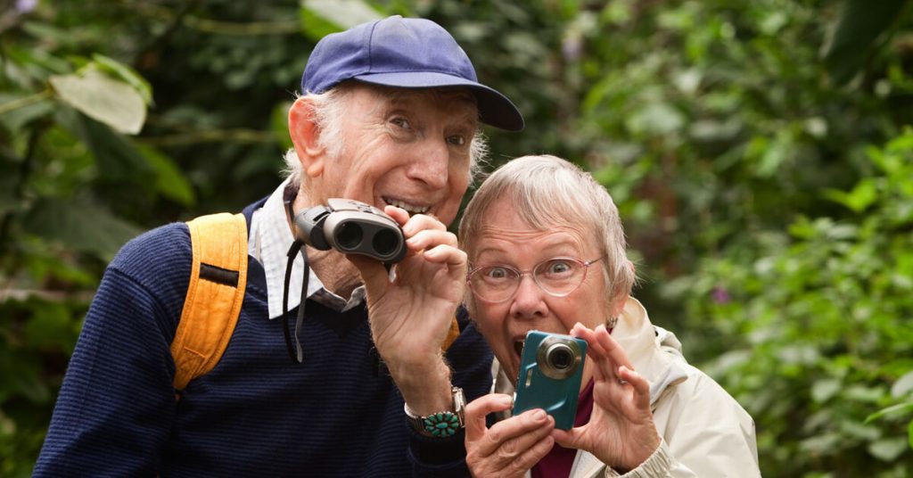 Senior couple taking pictures happily.