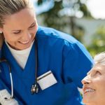 Nurse taking care of old woman in wheelchair