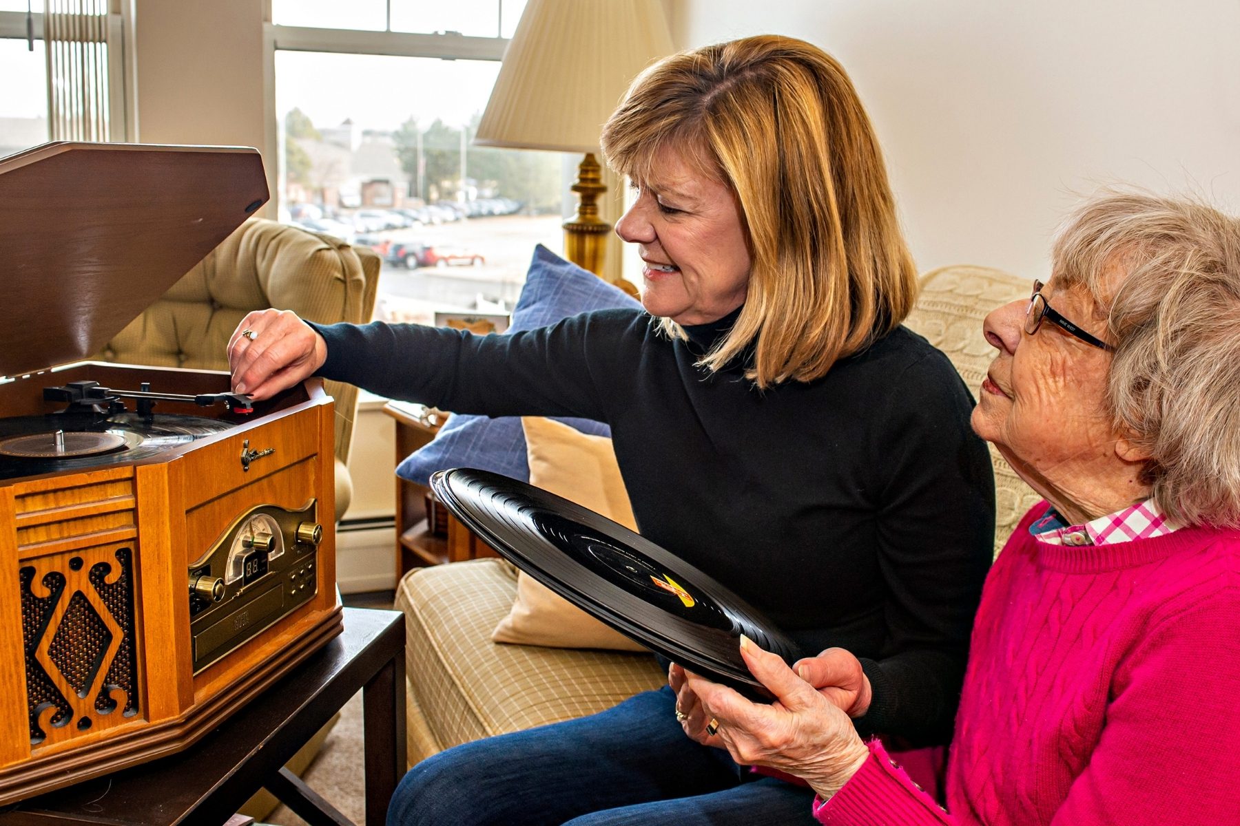 Someren Glen Senior Living Community in Centennial, CO - mother and daughter put a record on record player landscape