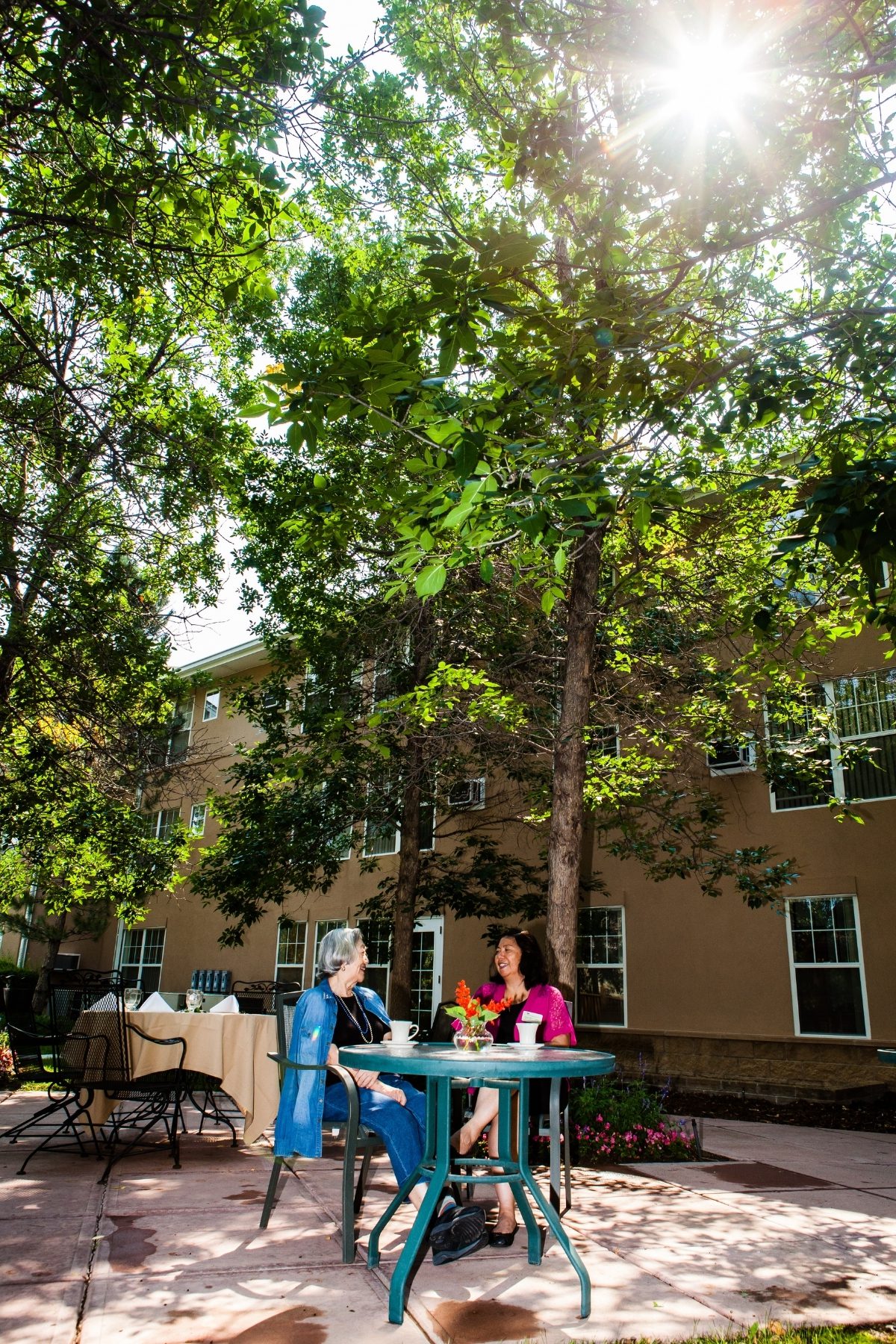 Someren Glen Senior Living Community in Centennial, CO - mom and daughter sitting at table outside portrait