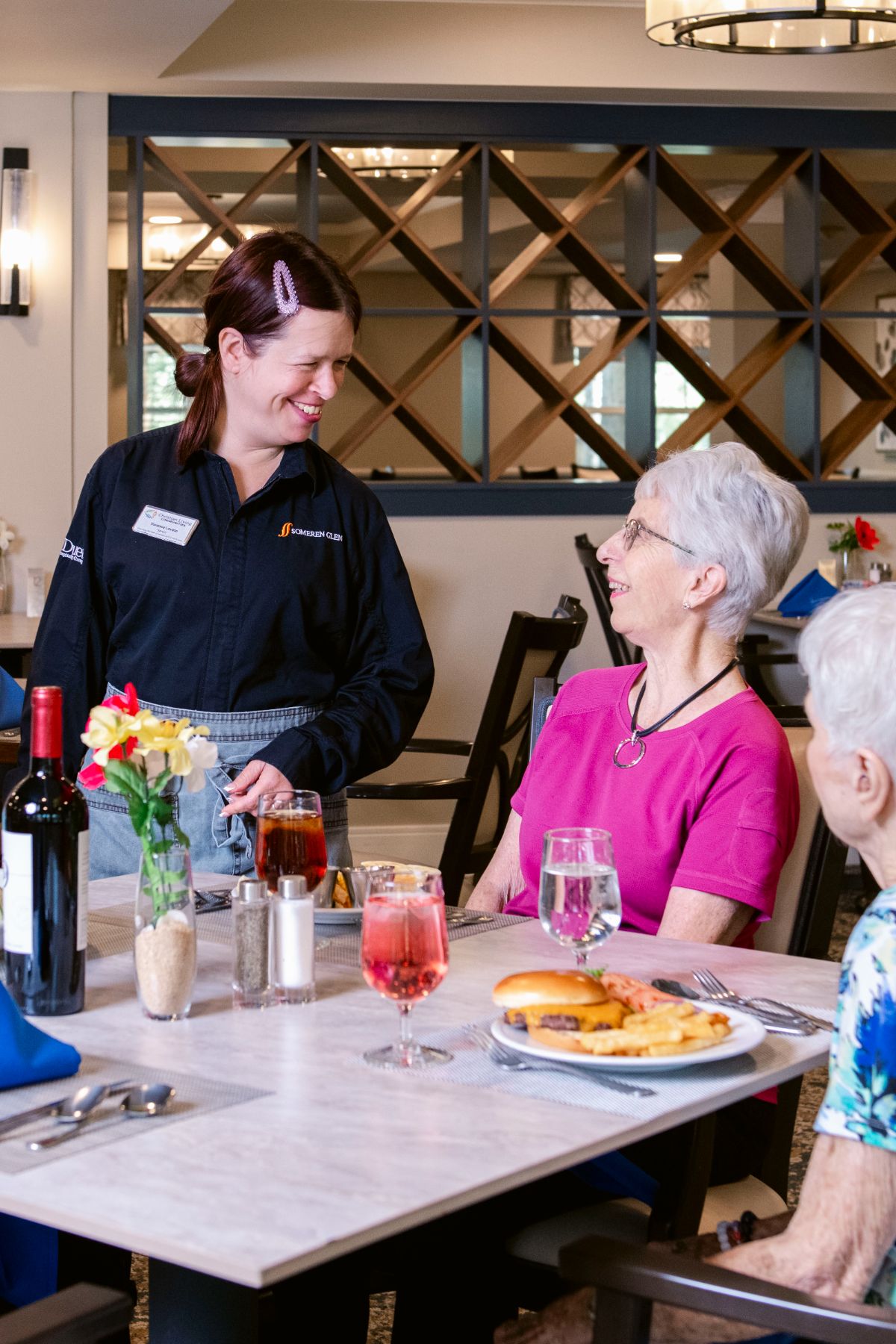 Someren Glen Senior Living Community in Centennial, CO - three residents and dining team member talking portrait