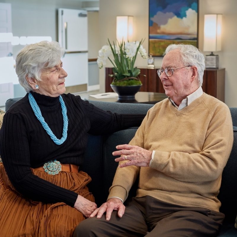 Someren Glen Senior Living Community in Denver, CO - older couple in discussion while seated on couch square