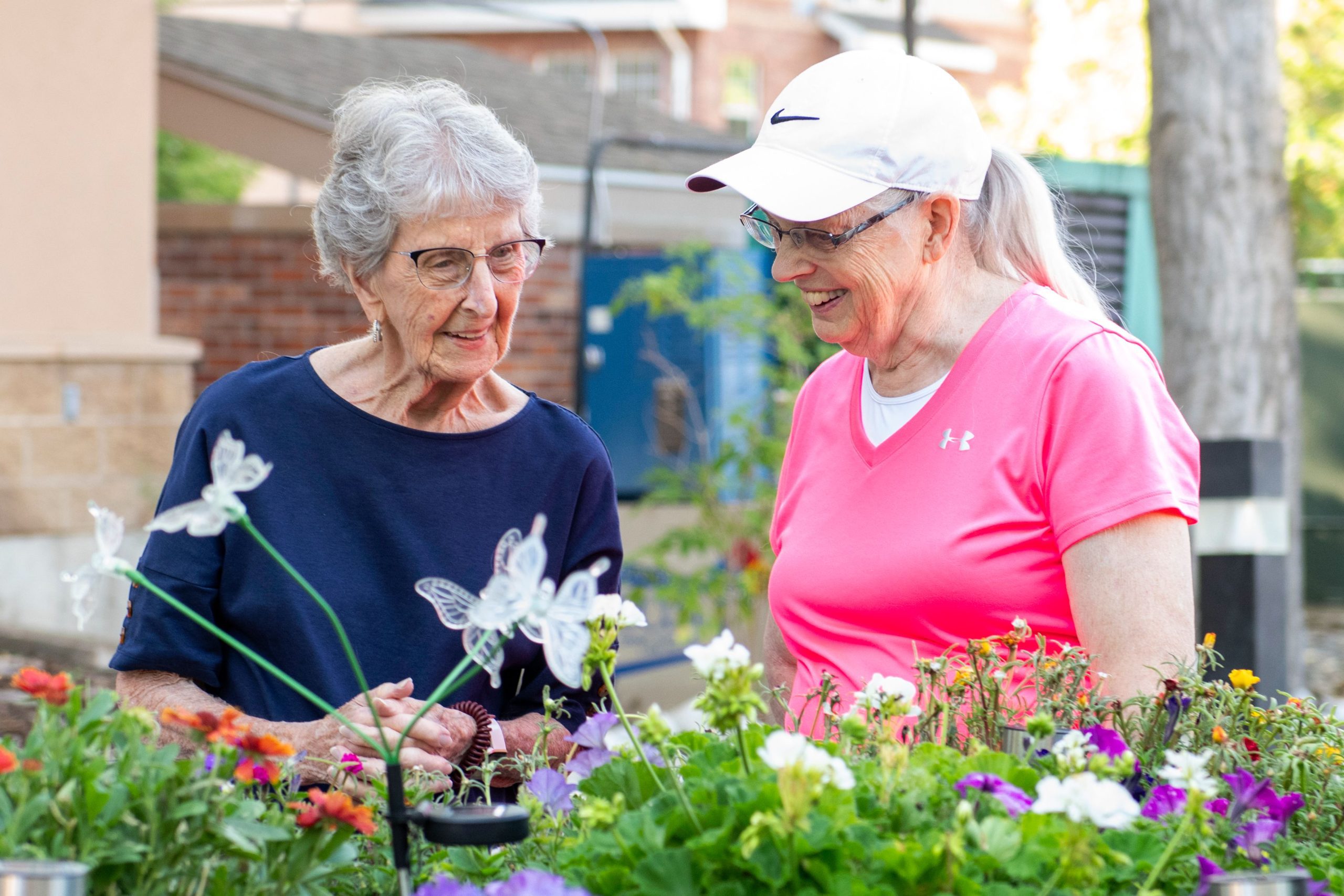 Someren Glen Senior Living Community in Centennial, CO - residents talking by flower gardens largelandscape