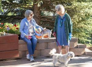 Someren Glen Senior Living Community in Centennial, CO - two women and their dogs taking a break on a walk