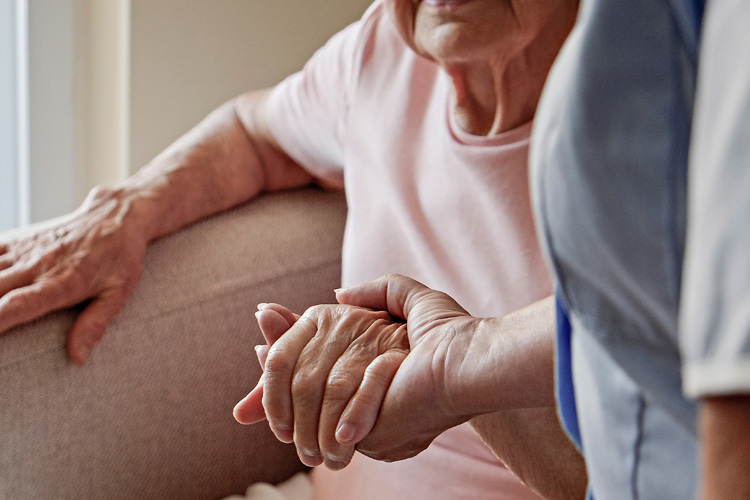 someren glen caregiver holding hand of senior woman resident Someren Glen Senior Living Community in Centennial, CO - someren glen caregiver holding hand of senior woman resident