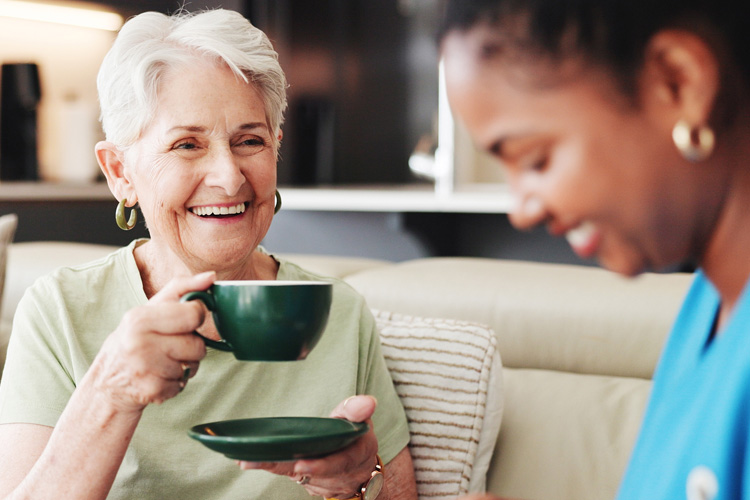 someren glen senior woman drinking coffee with caregiver Someren Glen Senior Living Community in Centennial, CO - someren glen senior woman drinking coffee with caregiver